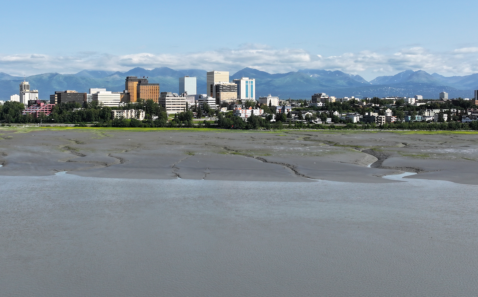 Extensive mudflats in front of Anchorage skyline.