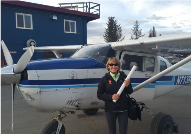 Woman standing next to small plane. 