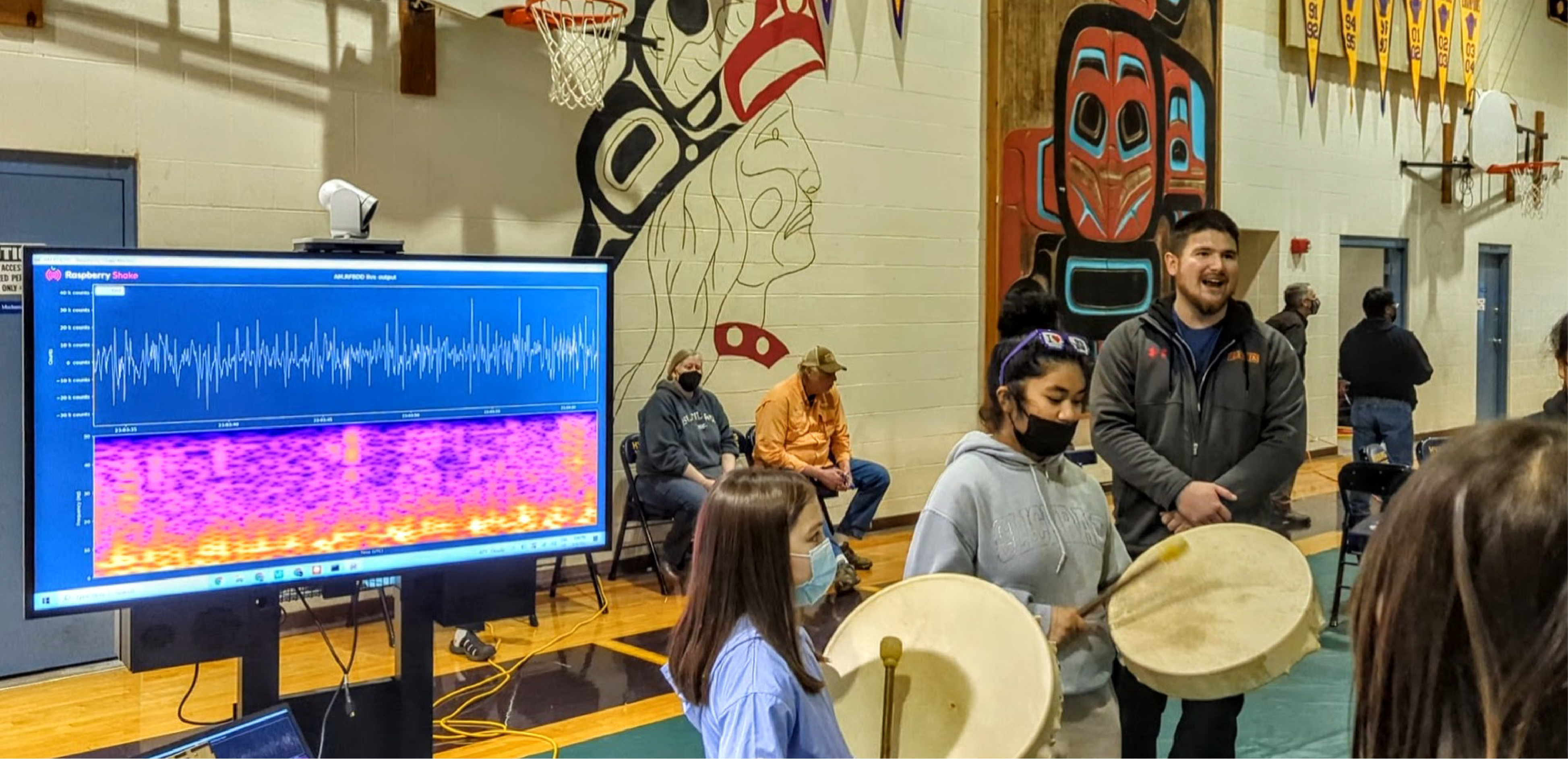 Students in Hydaburg drum traditional Haida songs with a live spectrogram behind them