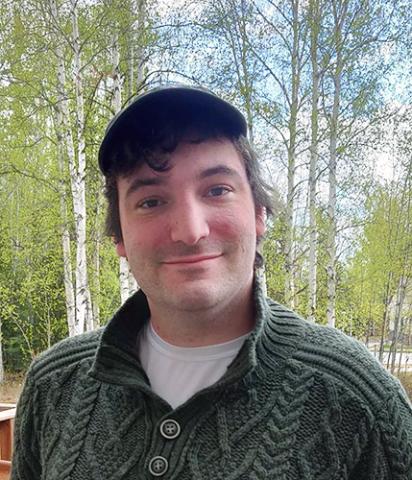 Young man with hat among birch trees