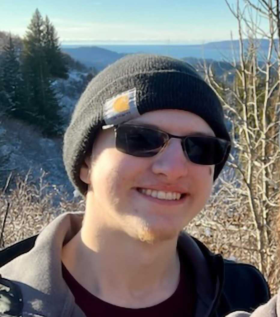 Devin Zigmont with sunglasses and spruce trees in background